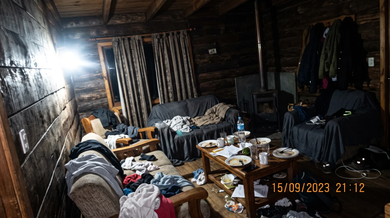 Living fotografiado de noche con flash directo, con desorden sobre los muebles, encuadre chueco y una fecha impresa sobre la imagen